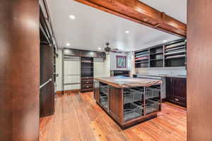 Kitchen with recessed lighting, light wood-type flooring, dark brown cabinets, ceiling fan, and open shelves