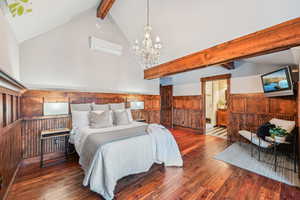 Bedroom with beam ceiling, hardwood / wood-style flooring, wood walls, a wainscoted wall, and high vaulted ceiling