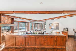 Kitchen with beam ceiling, dark wood-style flooring, light countertops, and recessed lighting