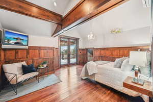 Bedroom featuring wood walls, french doors, a wainscoted wall, hardwood / wood-style floors, and access to exterior