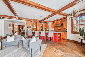 Living room featuring concrete floors, beam ceiling, and arched walkways