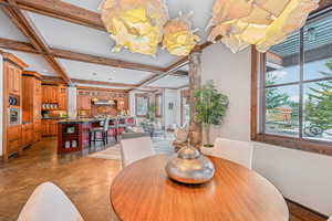 Dining room featuring beamed ceiling, coffered ceiling, and concrete flooring