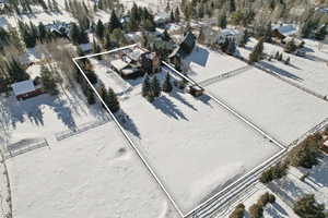 Snowy aerial view featuring property boundaries highlighted and a residential view
