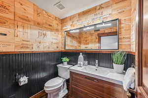 Bathroom with vanity and wooden walls