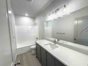 Bathroom featuring  shower combination, vanity, light wood-type flooring, and recessed lighting
