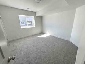 Unfurnished bedroom with carpet flooring and baseboards