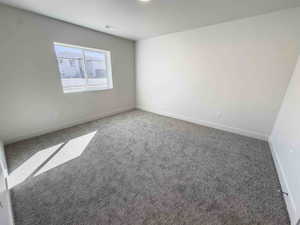 Carpeted empty room with baseboards