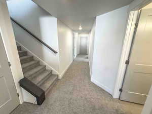 Corridor with stairs and light carpet