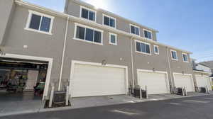 Back of house featuring stucco siding and a garage