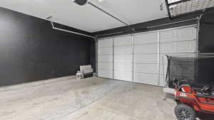Garage with baseboards and a garage door opener