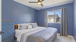 Carpeted bedroom with ceiling fan and baseboards