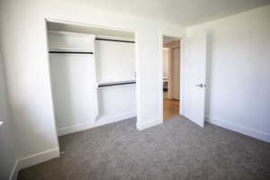 Unfurnished bedroom featuring light colored carpet and a closet