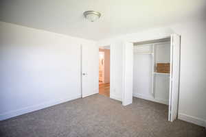 Unfurnished bedroom with carpet and a closet