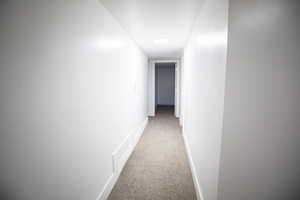 Corridor featuring carpet and baseboards
