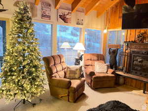 Living room with a fireplace with raised hearth, carpet, and wood ceiling