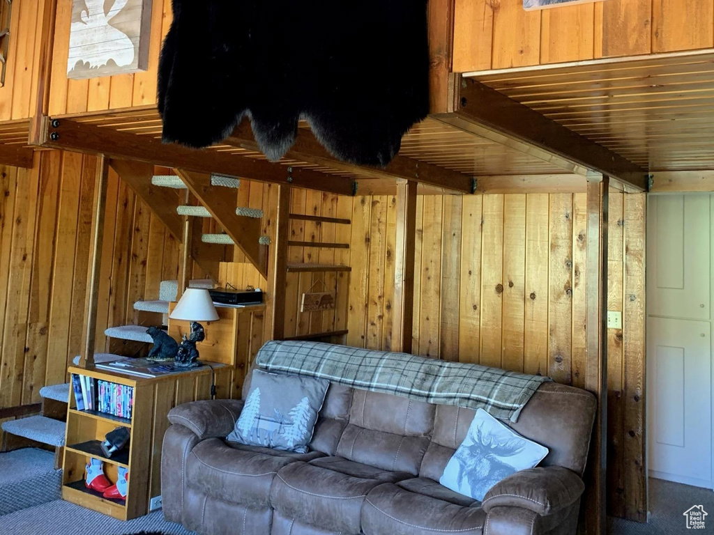 Living room with carpet floors and wood walls