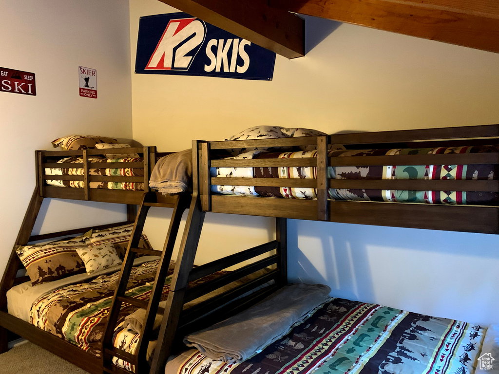Bedroom with beam ceiling and carpet floors