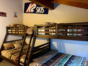 Bedroom with beam ceiling and carpet floors
