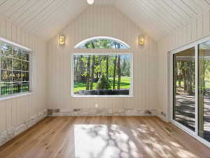 Dining room or sunroom with lofted ceiling, healthy amount of natural light, and natural stone.