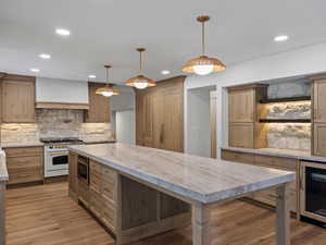 Kitchen featuring abundant stone, quartzite counters, handmade cabinets, and pendant lighting.