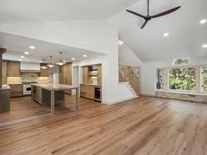 Kitchen featuring abundant stone, quartzite counters, handmade cabinets, and pendant lighting.