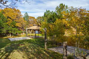 View of green lawn featuring a gazebo and a patio