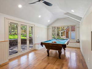 Recreation room featuring billiards table, lofted ceiling, a textured ceiling, light oak flooring, and a ceiling fan