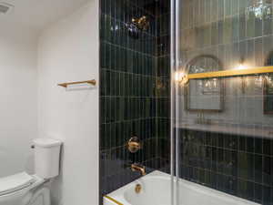 Full bathroom featuring enclosed tub / shower combo and toilet