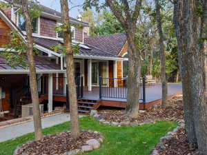 Back of property featuring a deck, a shingled roof, a standing seam roof, and a metal roof