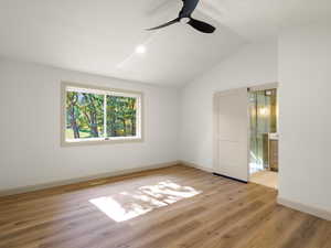 Primary bedroom with vaulted ceiling, LVP flooring, ceiling fan, and recessed lighting