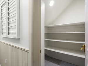 Laundry room with custom cabinets and counters. Wainscoted wall, hookup for a washing machine, cabinet space, and huge closet.