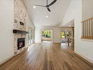 Unfurnished living room with high vaulted ceiling, LVP floors, recessed lighting, NEW fireplace, and french doors.