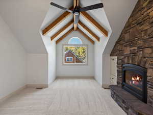 Unfurnished living room with light carpet, a gas fireplace, and a ceiling fan