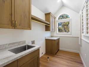 Laundry room with custom cabinets and counters. Wainscoted wall, hookup for a washing machine, cabinet space, and huge closet.