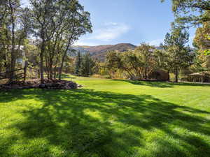 View of green lawn featuring a mountain view.