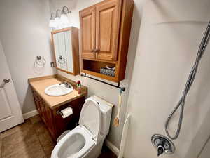 Full bathroom featuring vanity, dark tile patterned floors, and a shower