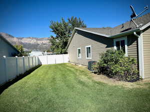 View of side of property featuring a fenced backyard and a mountain view
