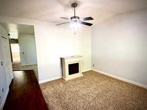 Unfurnished living room with a textured ceiling, a ceiling fan, and wood finished floors
