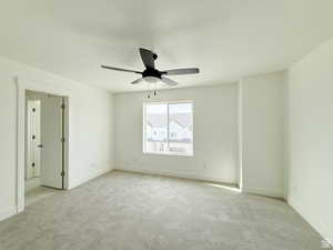 Unfurnished bedroom with light carpet, a ceiling fan, and a textured ceiling