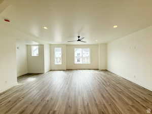 Unfurnished living room with ceiling fan, light wood-style floors, recessed lighting, and a textured ceiling