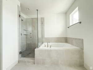 Bathroom with a garden tub, a stall shower, and tile patterned flooring