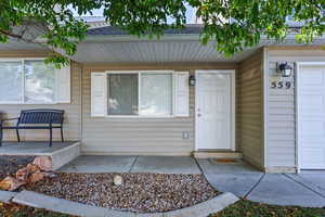 Entrance to property with a shingled roof and covered porch