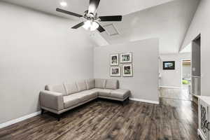 Living room with vaulted ceiling, dark wood finished floors, and ceiling fan
