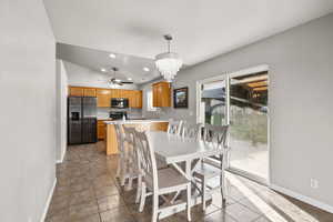 Dining space with a chandelier, lofted ceiling, light tile patterned flooring, and recessed lighting
