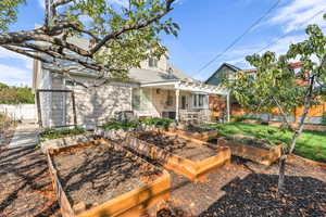 Back of house with a vegetable garden and a shingled roof