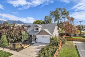 Traditional home with roof with shingles, concrete driveway, a mountain view, a garage, and a porch