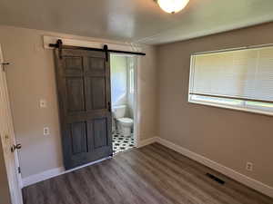 Foyer featuring dark wood-style flooring, a barn door, and a textured ceiling