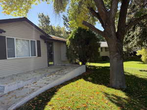 View of front facade with a front lawn and a deck