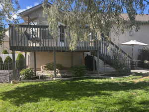 Back of property with stucco siding, stairway, a sunroom, and a wooden deckhttps://www.utahrealestate.com/lip/photo/listno/2116768#