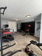 Workout area featuring a textured ceiling and carpet